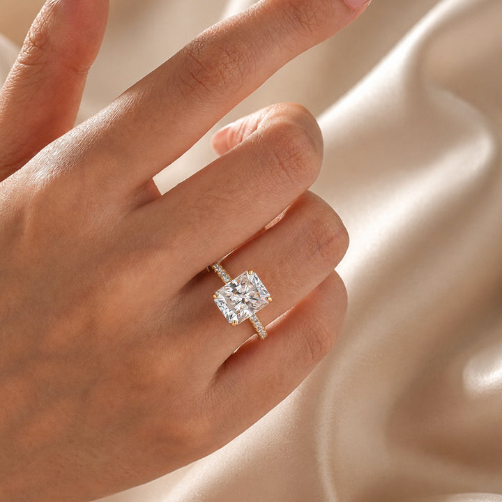 Radiant cut moissanite ring with round side stones worn on hand