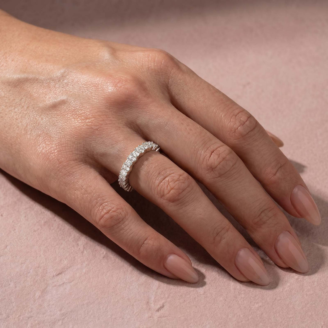 Full eternity moissanite wedding band styled on finger