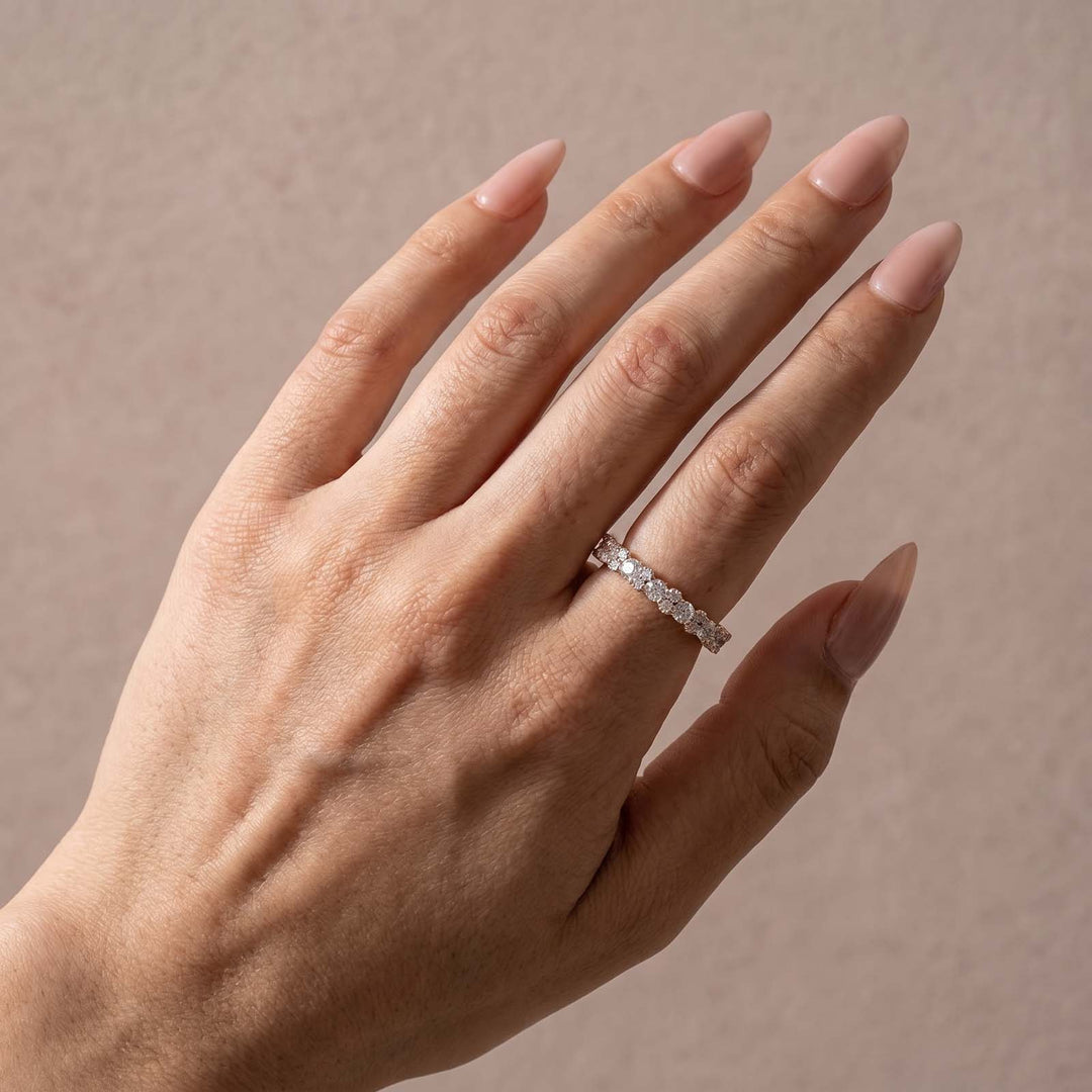 Yellow gold round stone eternity band shown on hand