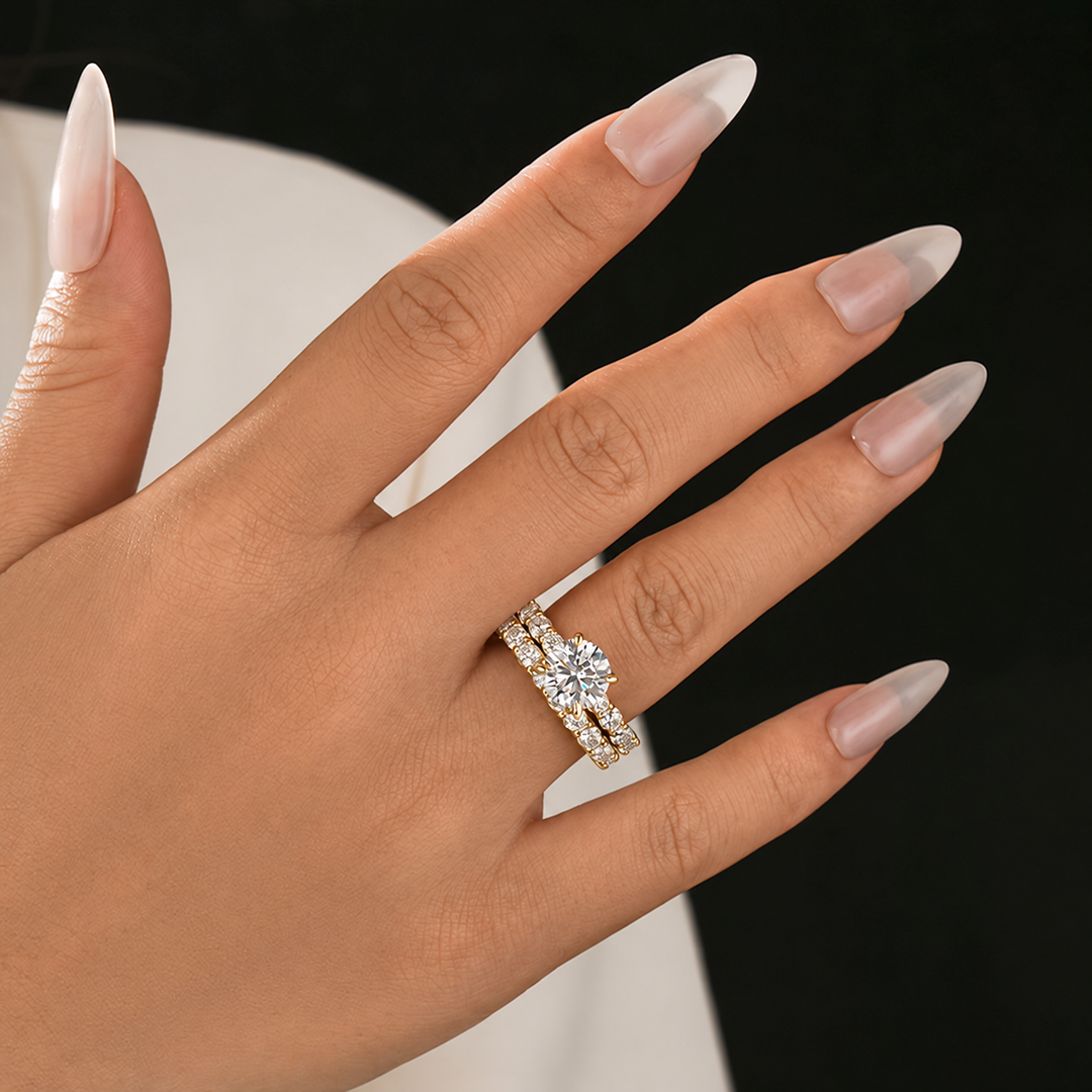 Round moissanite bridal set shown on the hand with a dark background