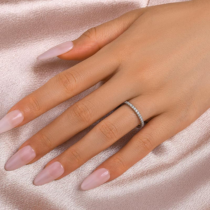 White gold stackable moissanite wedding band styled on finger