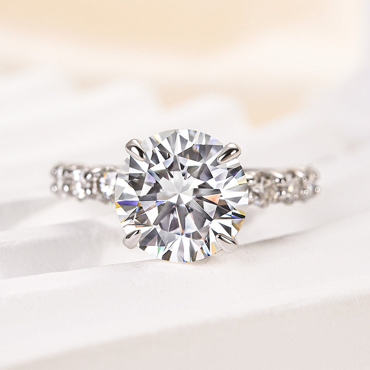 Front view of round moissanite engagement ring showing the center stone and side accents