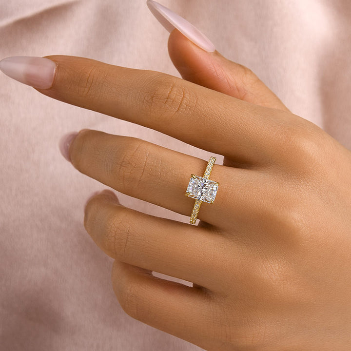 Yellow gold radiant moissanite engagement ring worn on hand