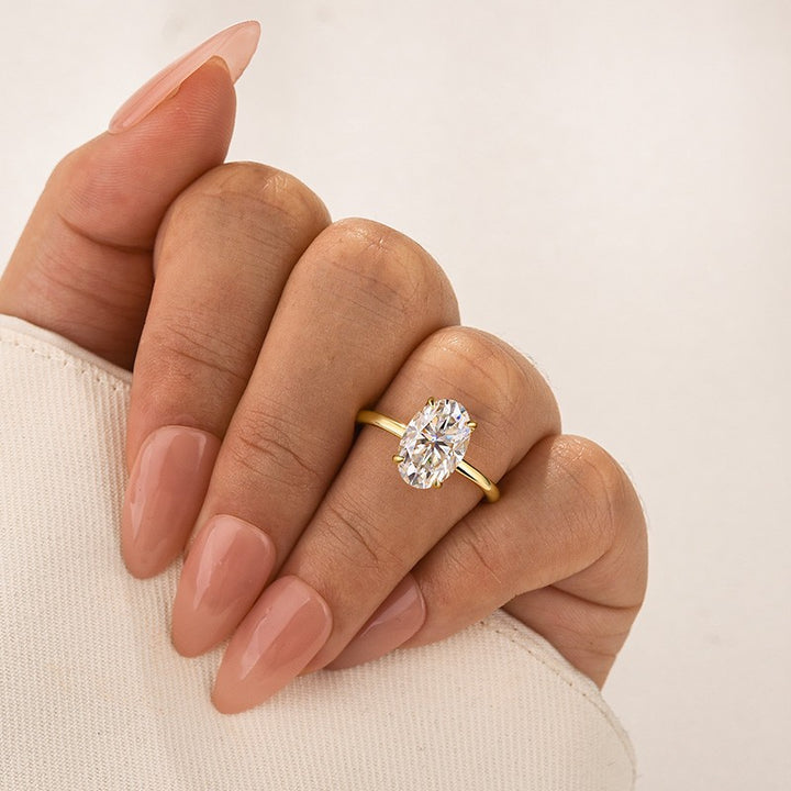 Yellow gold hidden halo oval moissanite ring worn on hand