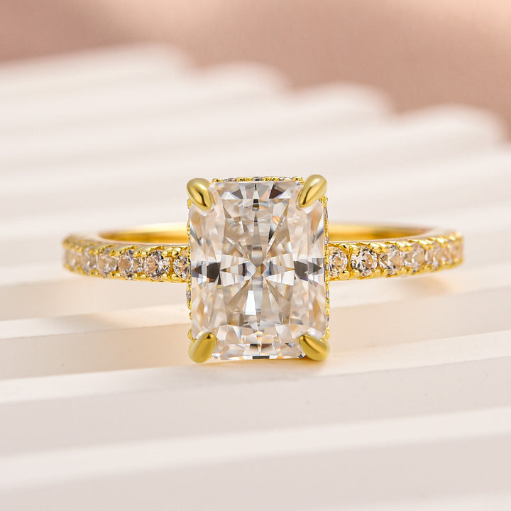 Front view of a radiant moissanite ring with pavé half eternity band