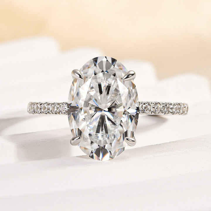 Front view of a white gold pavé oval moissanite ring