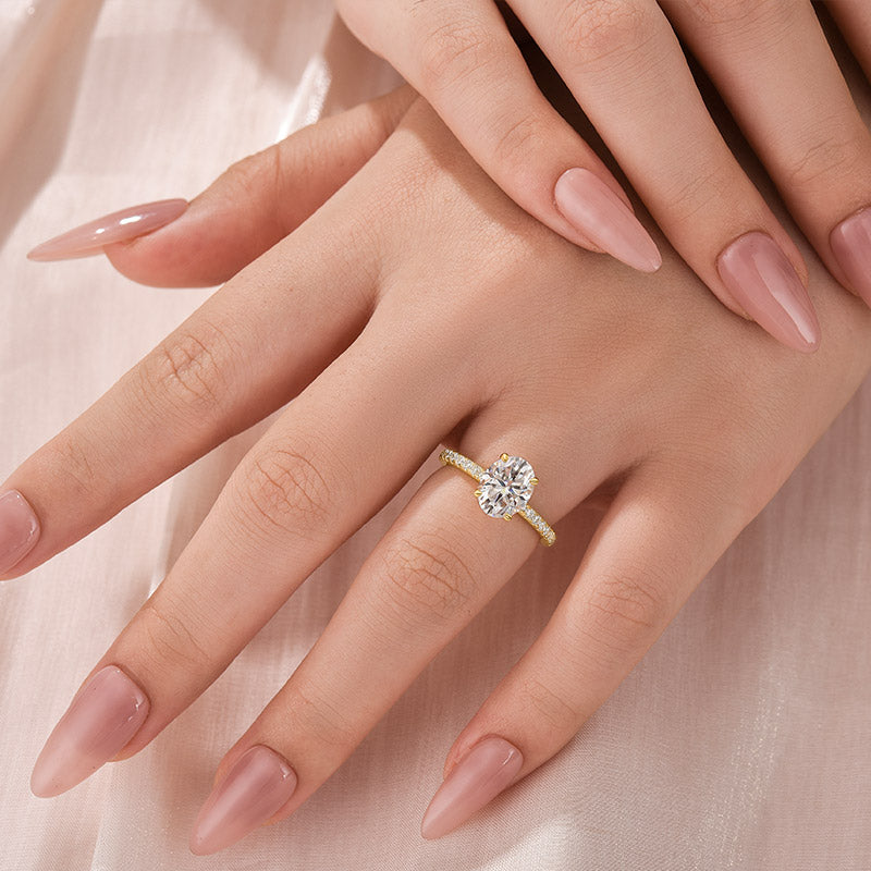 Yellow gold oval moissanite engagement ring worn on hand