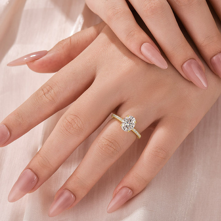 Yellow gold oval moissanite engagement ring worn on hand