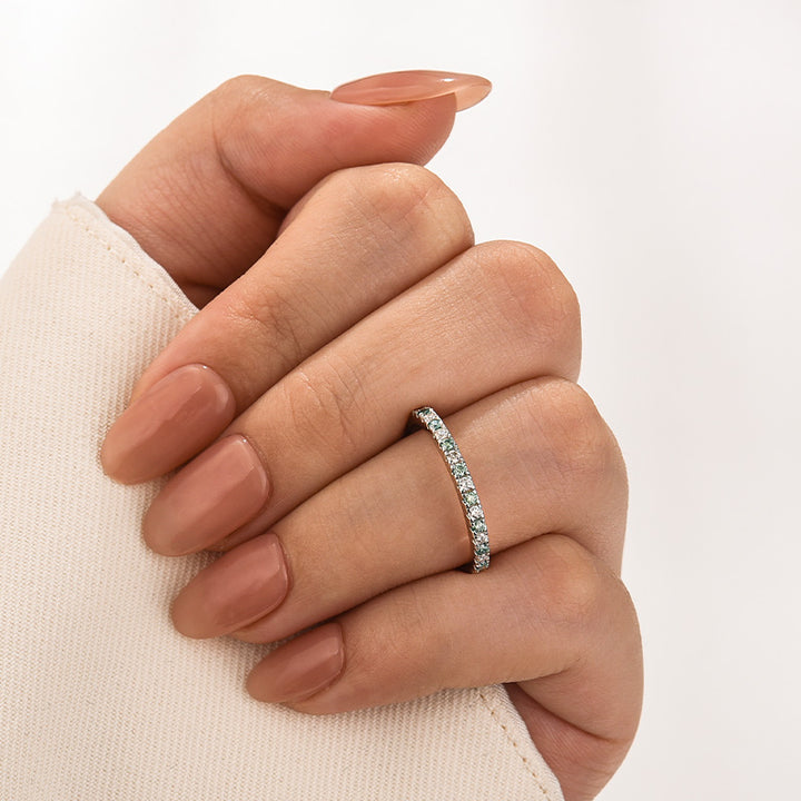 Round half halo moissanite ring shown on finger in a close-up view