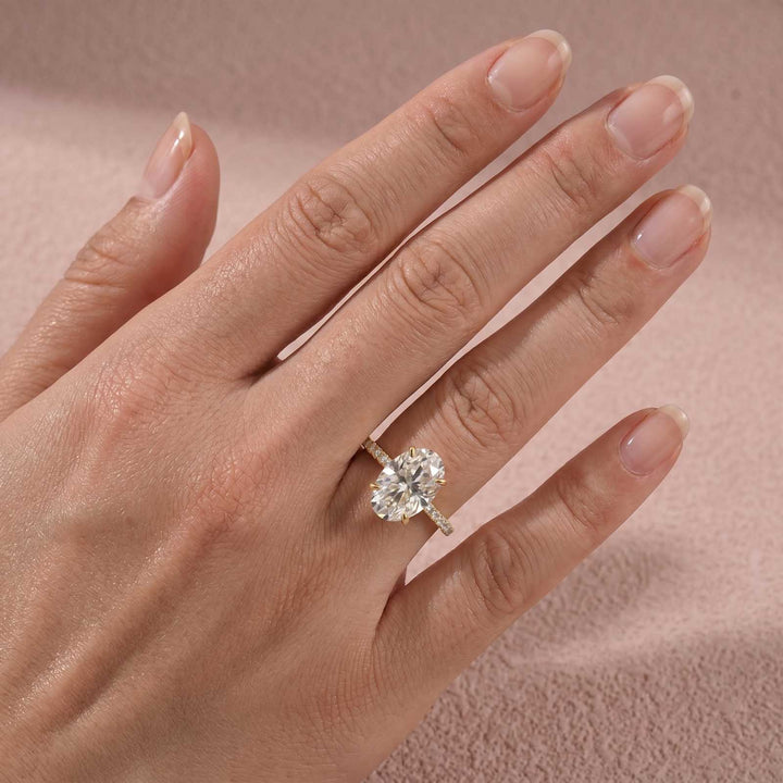 Oval moissanite ring with pavé side stones worn on hand