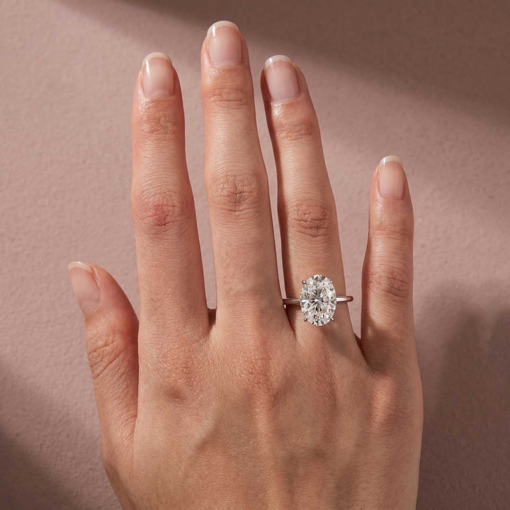 Hidden halo oval moissanite promise ring shown on finger